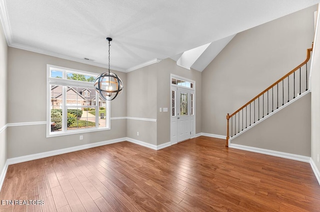 unfurnished dining area featuring visible vents, wood finished floors, stairway, baseboards, and a chandelier