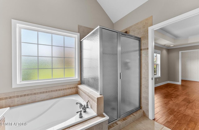 full bathroom with crown molding, wood finished floors, vaulted ceiling, a bath, and a stall shower