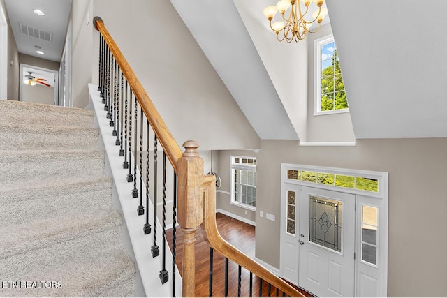 foyer featuring visible vents, wood finished floors, stairway, recessed lighting, and a notable chandelier