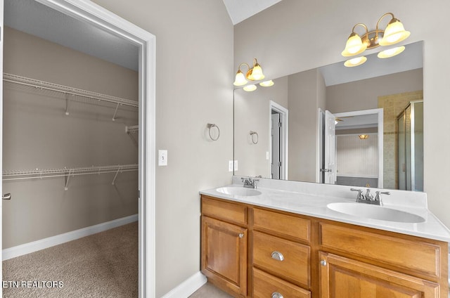 full bath with a sink, a spacious closet, and a shower stall