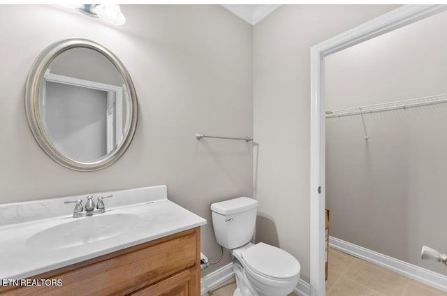 bathroom with tile patterned flooring, vanity, baseboards, toilet, and ornamental molding