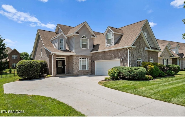 view of front of house featuring fence, a front lawn, stone siding, a garage, and concrete driveway