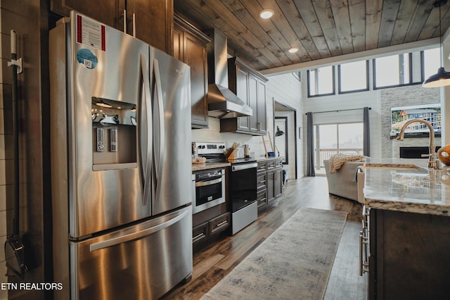 kitchen featuring wall chimney exhaust hood, appliances with stainless steel finishes, wooden ceiling, light stone counters, and recessed lighting