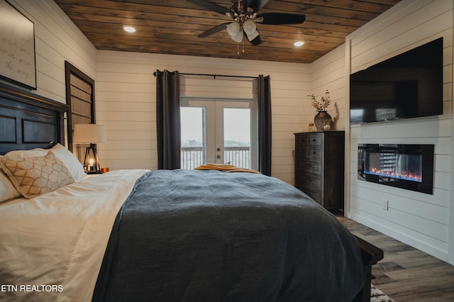bedroom with wooden ceiling, dark wood-style flooring, french doors, and a glass covered fireplace