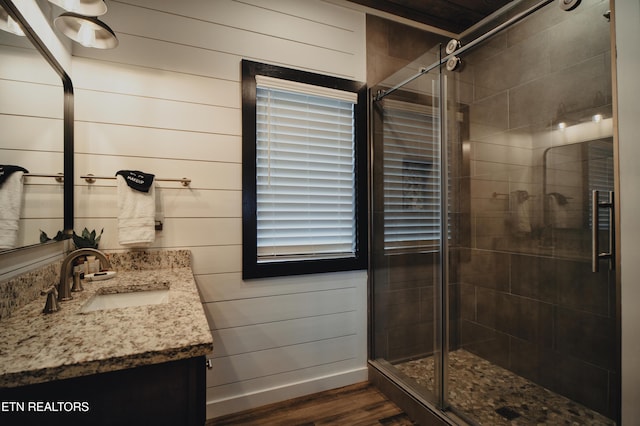 full bath featuring a shower stall, vanity, and wood finished floors