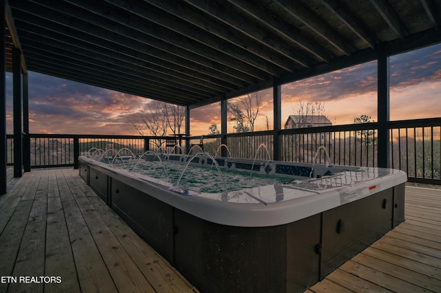 wooden terrace with an outdoor hot tub and a sink
