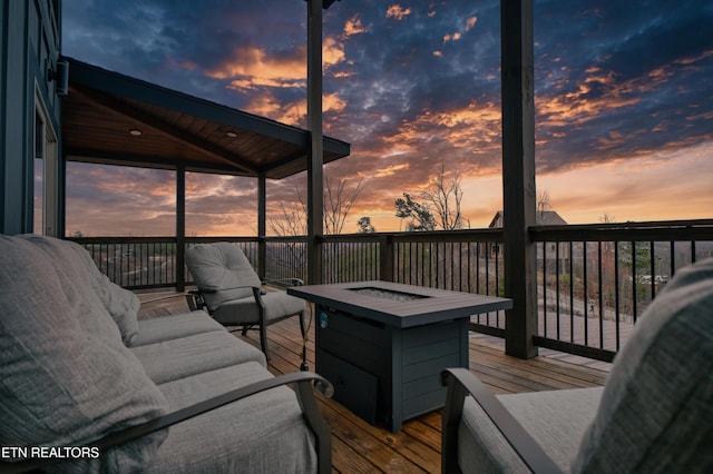 deck at dusk featuring an outdoor fire pit