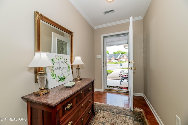 doorway to outside featuring baseboards, ornamental molding, and visible vents