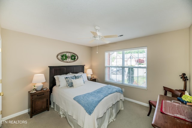 bedroom featuring baseboards, light carpet, and a ceiling fan