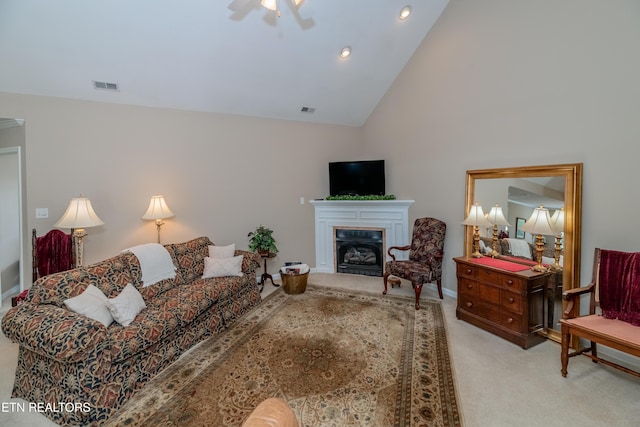 living area with a fireplace, light carpet, a ceiling fan, and visible vents