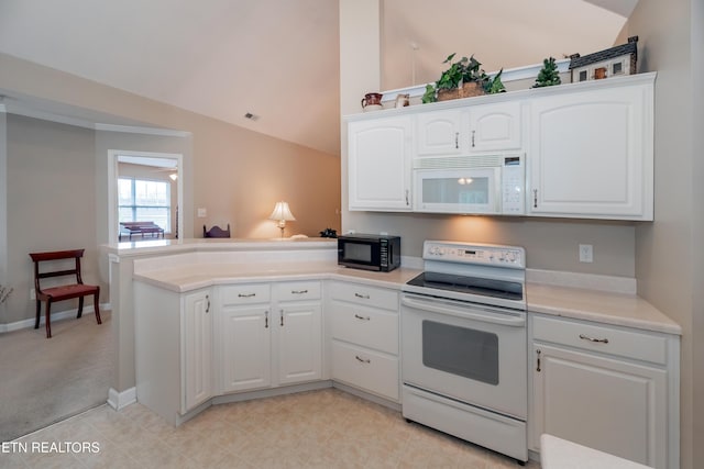 kitchen with lofted ceiling, white appliances, a peninsula, light countertops, and white cabinets