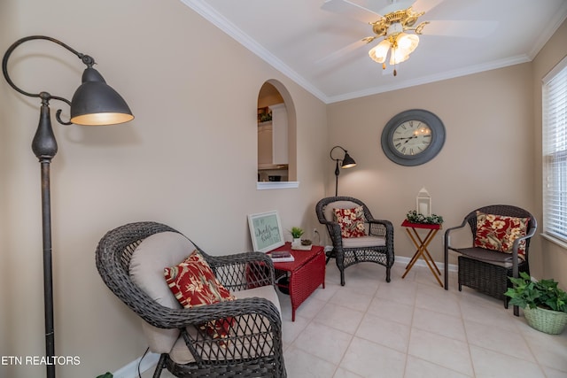 living area with crown molding, light tile patterned floors, baseboards, and ceiling fan
