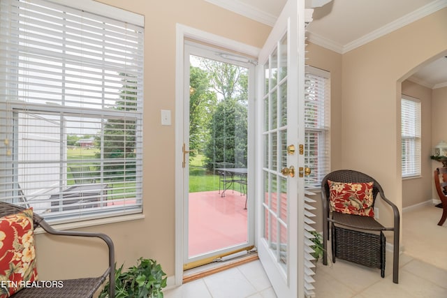 doorway featuring arched walkways, ornamental molding, tile patterned flooring, and baseboards