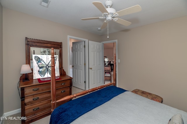 carpeted bedroom with visible vents, baseboards, and a ceiling fan