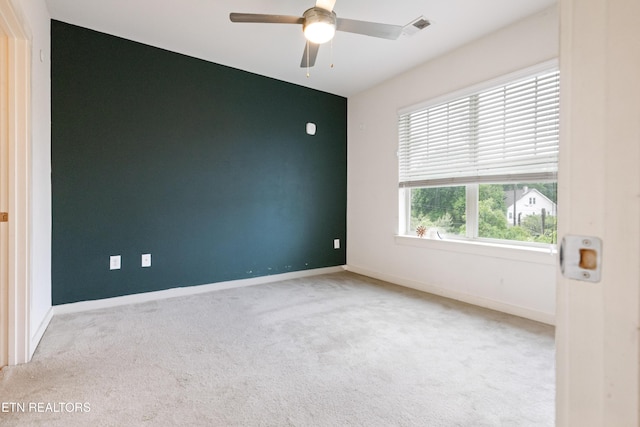 spare room with a ceiling fan, carpet flooring, visible vents, and baseboards