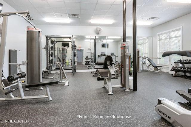 gym with a paneled ceiling and visible vents
