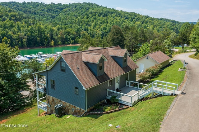 aerial view with a water view and a wooded view