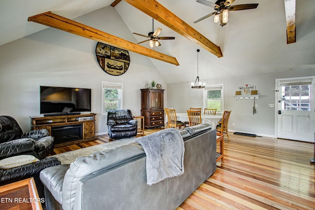 living room with plenty of natural light, beam ceiling, and ceiling fan with notable chandelier