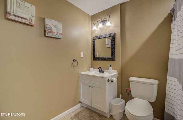 bathroom featuring vanity, tile patterned flooring, baseboards, and toilet