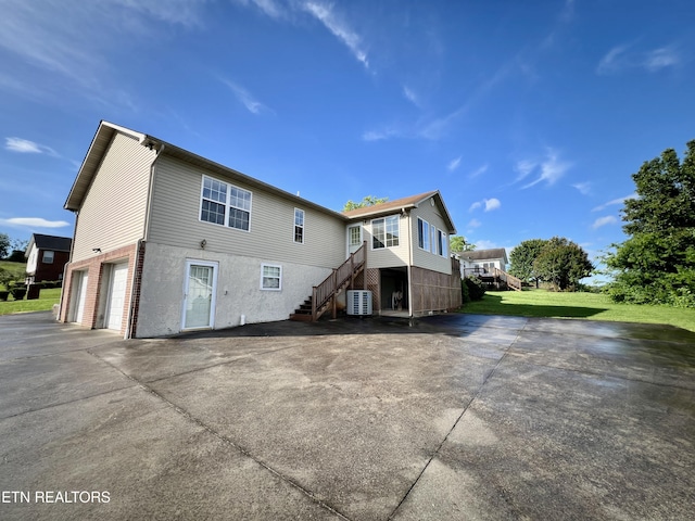 1533 Kildee Ln, Sevierville, TN 37862 - back of property with an attached garage, concrete driveway, stairway, a yard, and brick siding