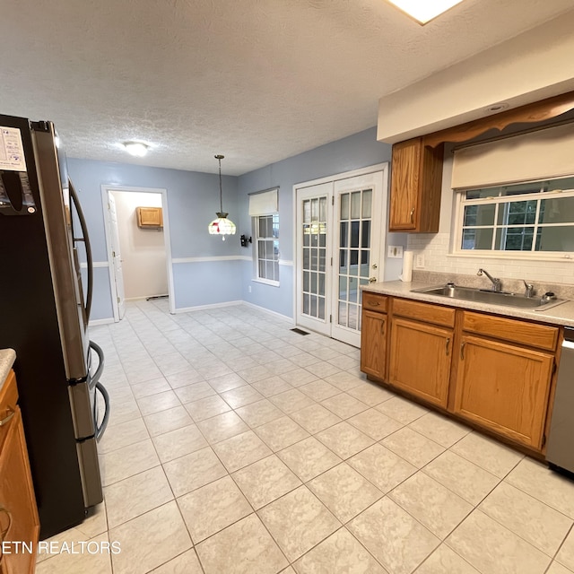 1533 Kildee Ln, Sevierville, TN 37862 - kitchen featuring stainless steel appliances, a sink, brown cabinets, light countertops, and a textured ceiling
