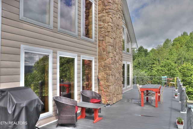 deck featuring grilling area and outdoor dining space