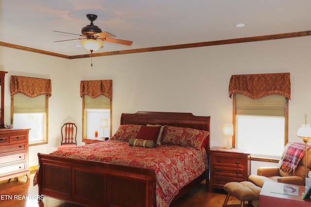 bedroom with wood finished floors, ornamental molding, multiple windows, and a ceiling fan
