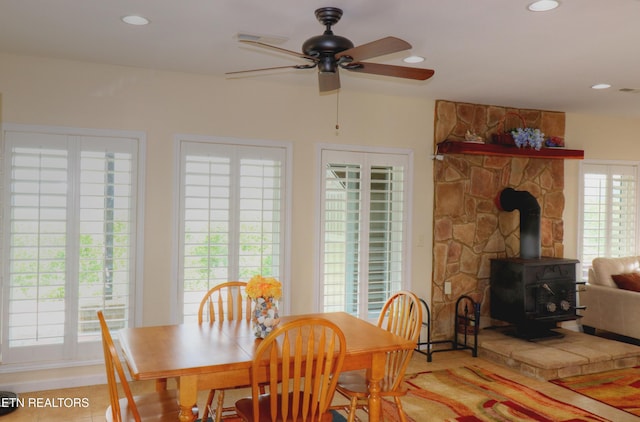 dining space with ceiling fan, a wood stove, and recessed lighting