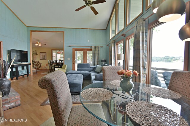 dining space with ceiling fan, high vaulted ceiling, wood finished floors, and ornamental molding