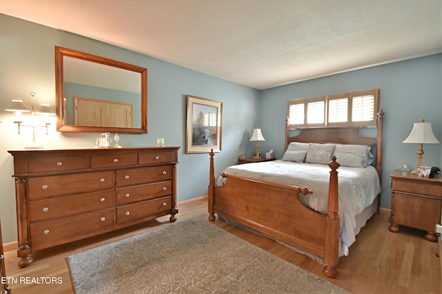 bedroom featuring light wood-style flooring and baseboards