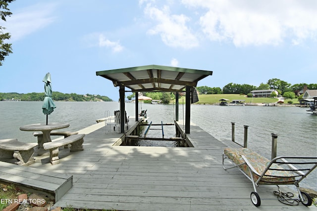 dock area featuring boat lift and a water view