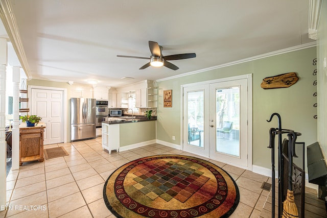 kitchen featuring a peninsula, light tile patterned floors, dark countertops, stainless steel appliances, and a wealth of natural light