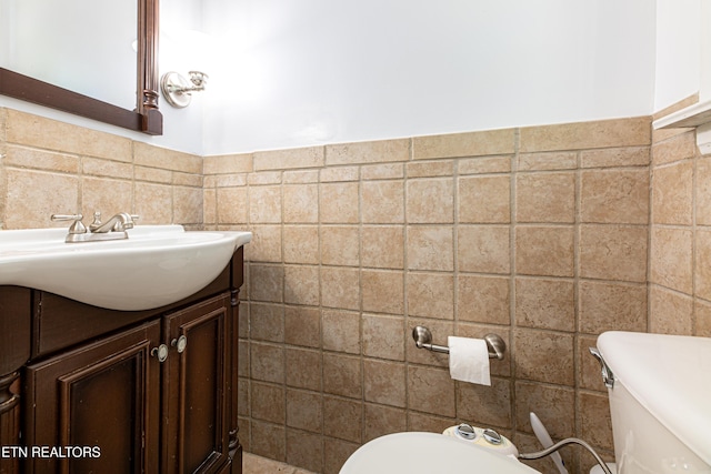 half bath featuring vanity, tile walls, and toilet