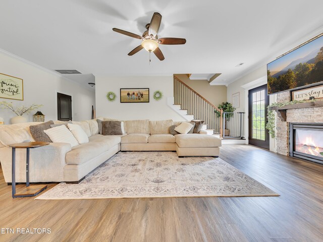 1810 Griffitts Mill Cir, Maryville, TN 37803 - living room featuring stairs, wood finished floors, ceiling fan, crown molding, and a stone fireplace