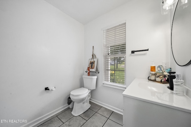 half bath featuring tile patterned floors, toilet, baseboards, and vanity