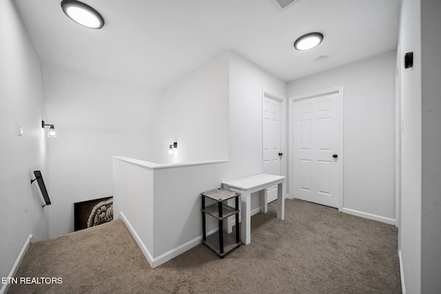 hall featuring baseboards, carpet flooring, and an upstairs landing