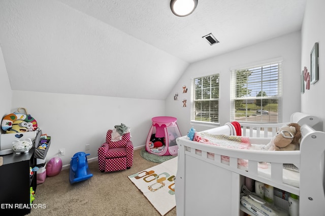 carpeted bedroom with vaulted ceiling, a textured ceiling, and visible vents