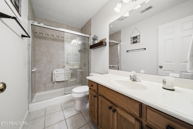 full bath featuring toilet, visible vents, tile patterned flooring, a shower stall, and vanity