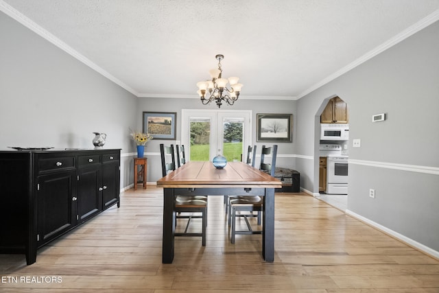 dining room with crown molding, a notable chandelier, light wood-type flooring, and baseboards
