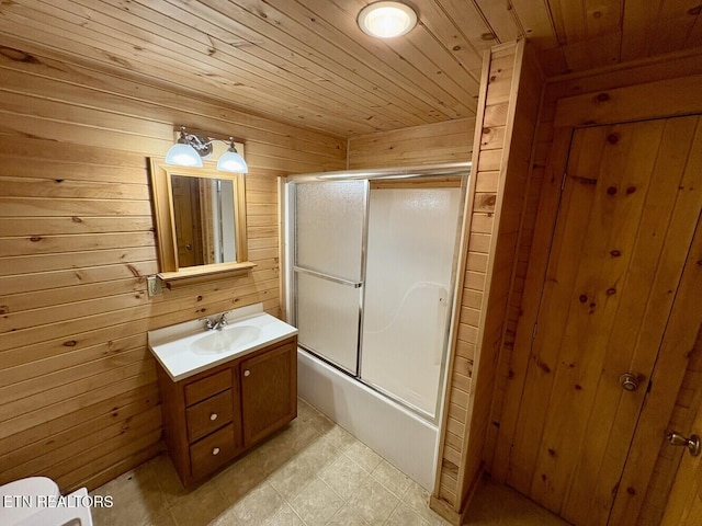 full bathroom with vanity, tile patterned floors, wooden walls, bath / shower combo with glass door, and wood ceiling