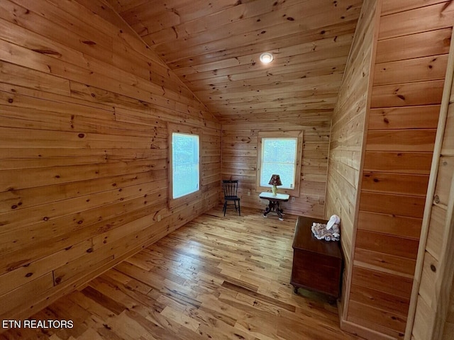 interior space featuring light wood-style floors, wooden walls, wood ceiling, and vaulted ceiling