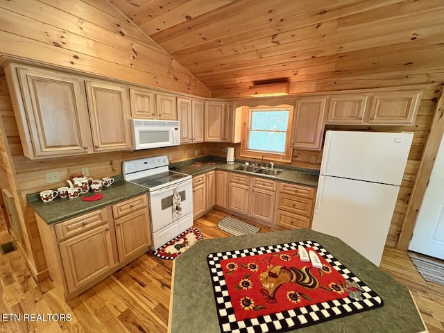 kitchen with white appliances, dark countertops, a sink, and vaulted ceiling