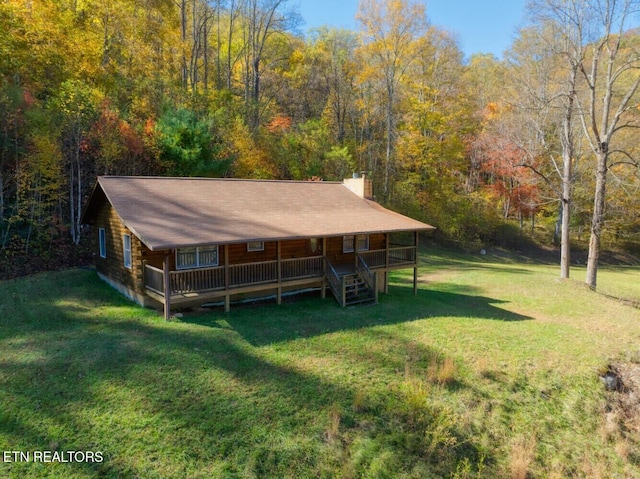 exterior space with covered porch and a wooded view