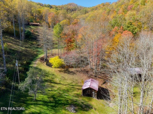 birds eye view of property featuring a wooded view