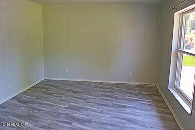 empty room with baseboards and wood finished floors
