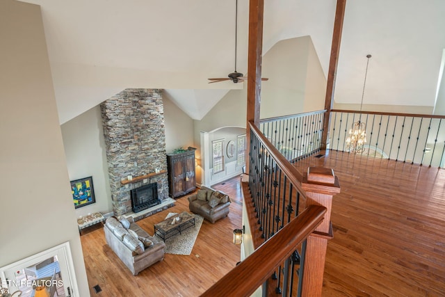 205 Melea Ln, Kingston, TN 37763 - living room with ceiling fan, wood finished floors, arched walkways, a stone fireplace, and a chandelier