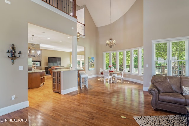 205 Melea Ln, Kingston, TN 37763 - living room featuring a chandelier, light wood-style flooring, baseboards, healthy amount of natural light, and high vaulted ceiling