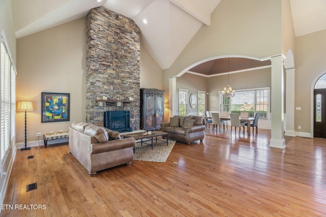 205 Melea Ln, Kingston, TN 37763 - living room featuring decorative columns, high vaulted ceiling, a chandelier, light wood-style flooring, and a fireplace