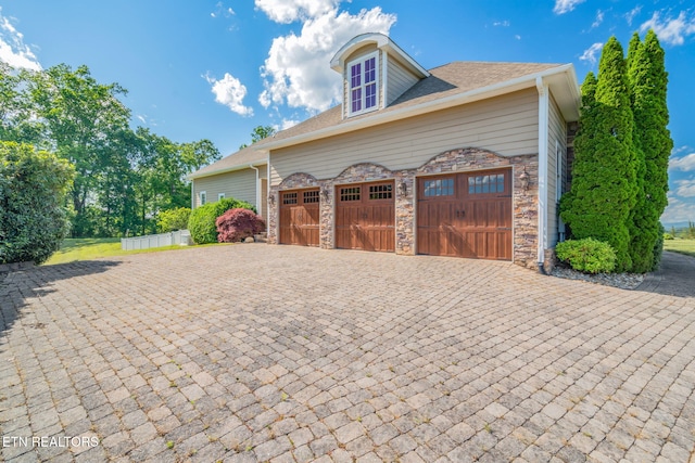 205 Melea Ln, Kingston, TN 37763 - view of property exterior with decorative driveway, stone siding, a shingled roof, and an attached garage