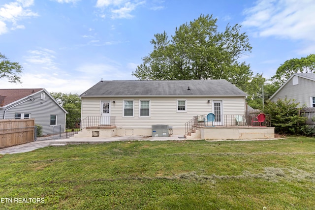back of house featuring central air condition unit, a patio area, fence, and a lawn